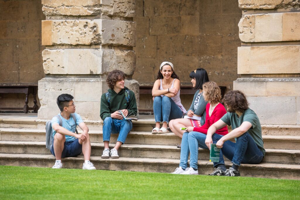 Image shows group of students sitting on steps