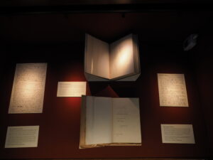 an exhibition case containing open books and captions