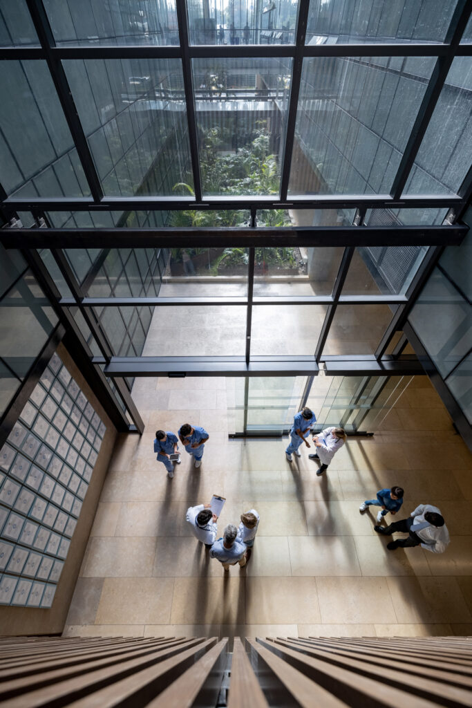 doctors and patients talking at the entrance hall of a hospital on a busy day