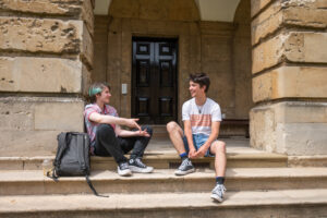 two students sitting on the steps talking
