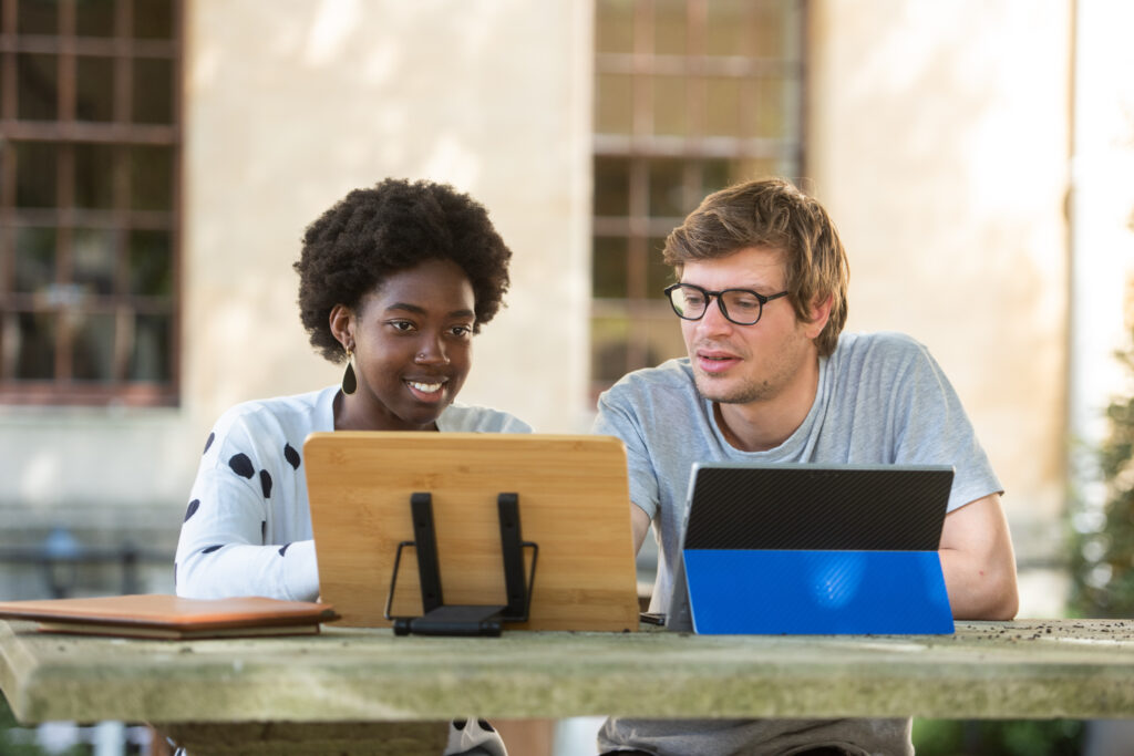 two students looking at tablets and chatting