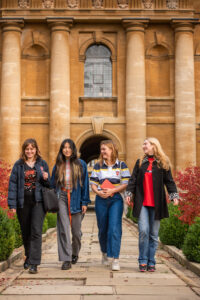 four students walking along the central path in Front Quad