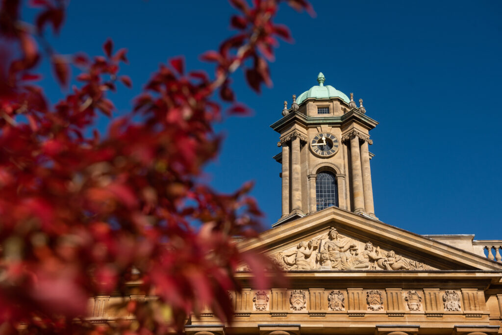 The clock tower framed with red leaves