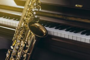 Close up of alto saxophone over piano keys
