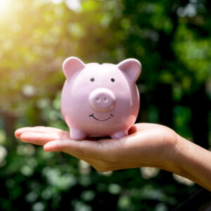 smiling pink piggy bank resting in someone's hand