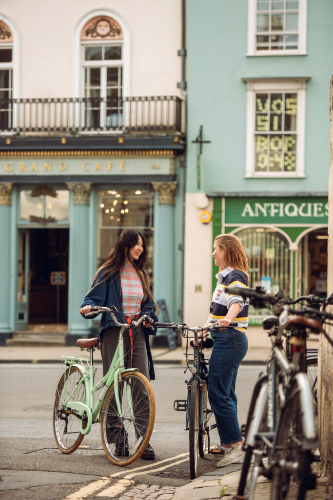 students with their bicycles on Queen's Lane