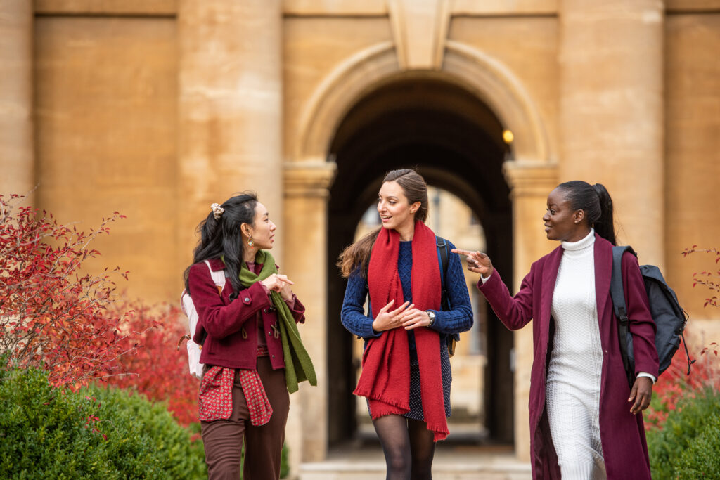 three students walking down the central aisle of Front Quad