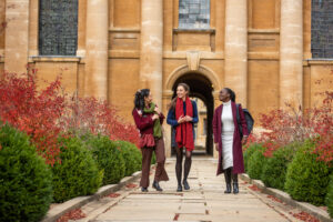 three students in Front Quad in autumn