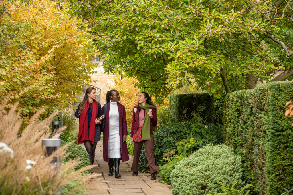three students walking in the College garden