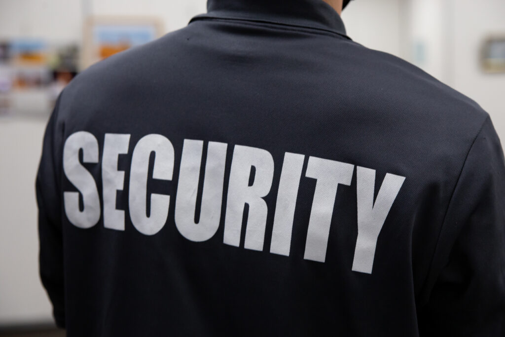 person from behind with security written on the back of the t-shirt