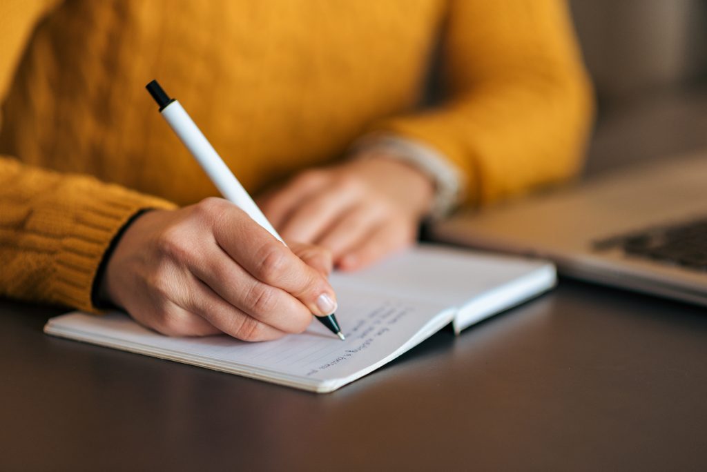 person writing in a notebook