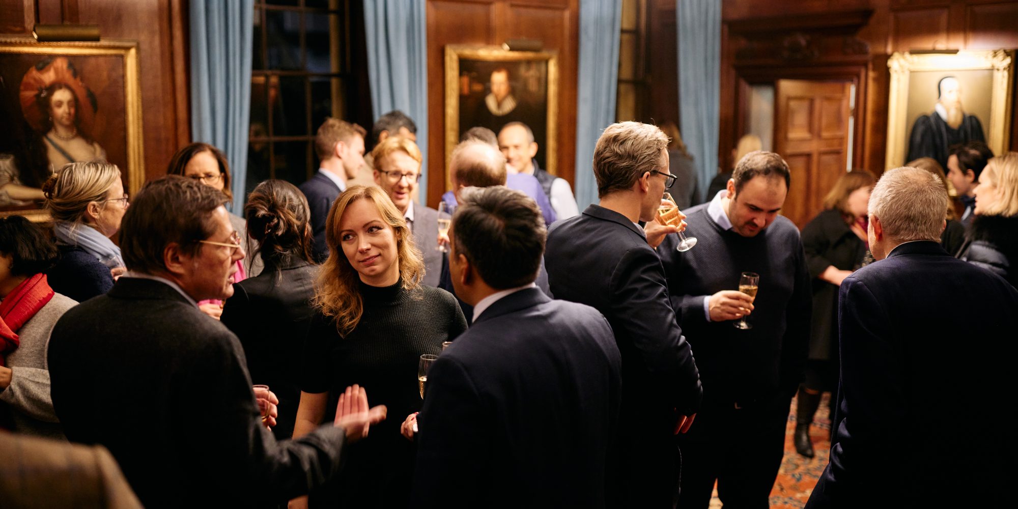 People standing and talking in the Magrath Room