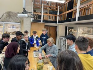 North West Science Residential: students gathered around a table for a science demo