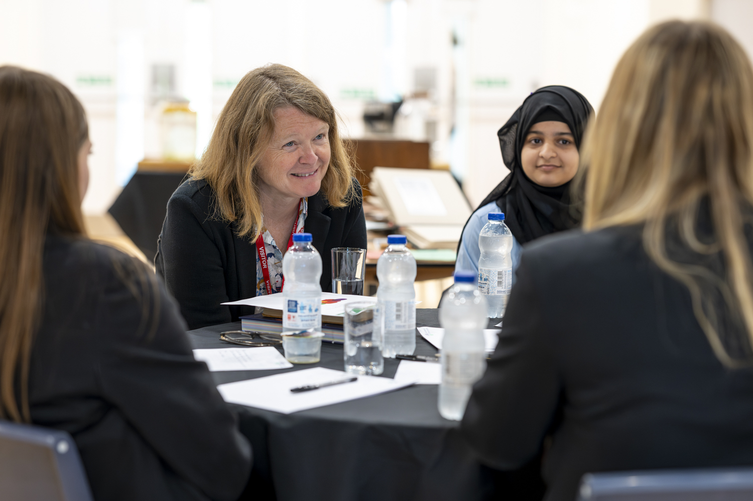 Outreach Fellow Prof Lindsay Turnbull pictured sitting at a table with three students