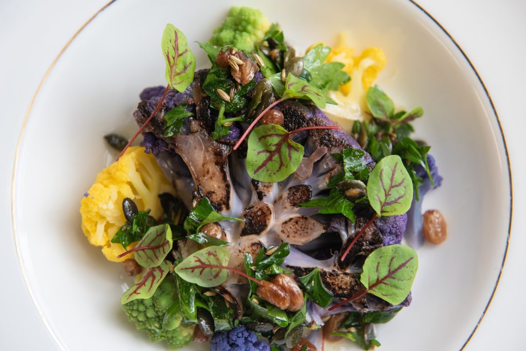 colourful plate of food with green leaves and purple sprouting broccoli