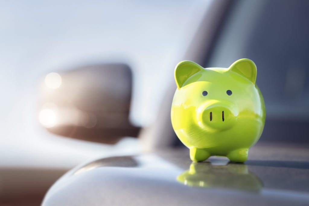 green piggy bank on a table with a blurred out background