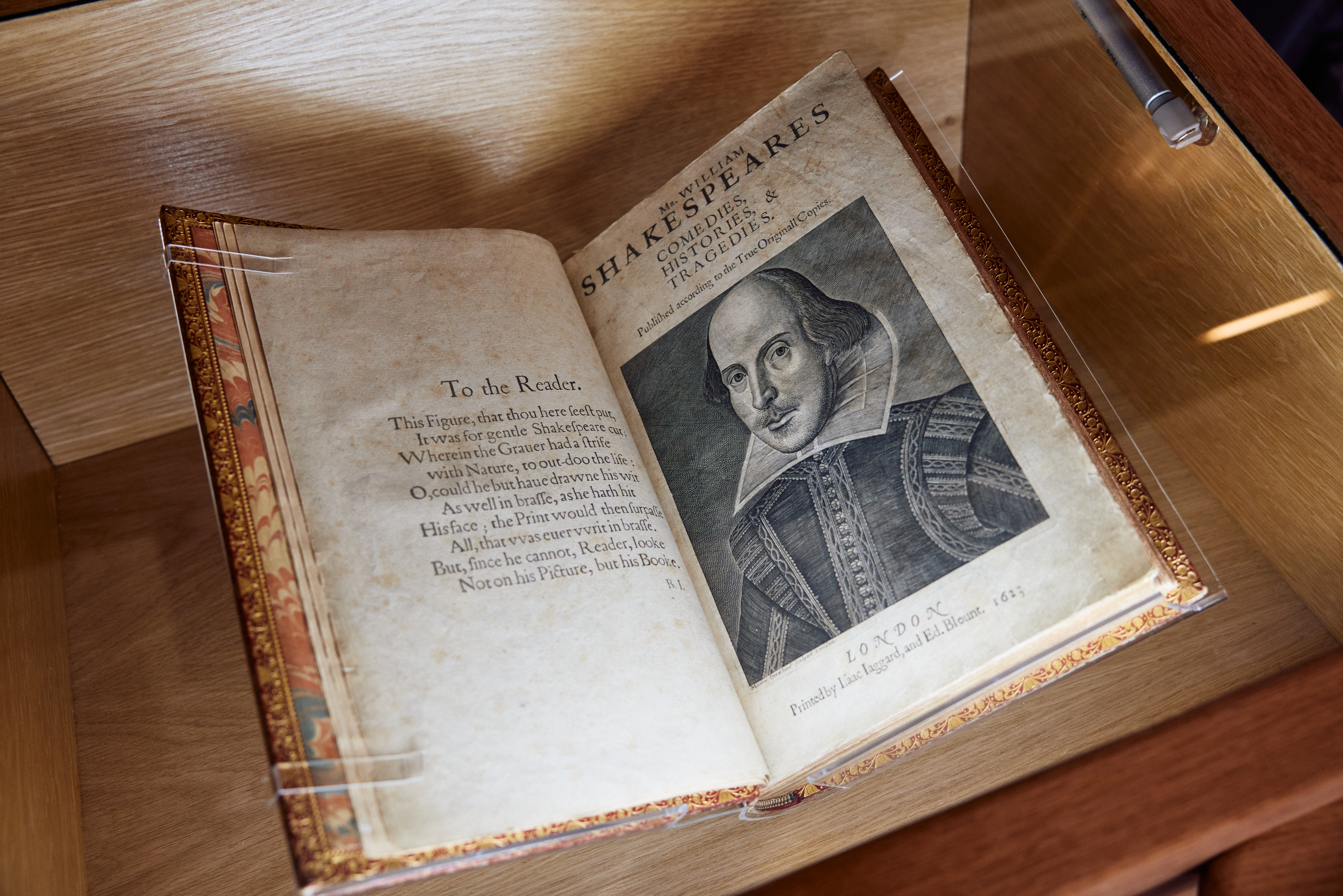 Shakespeare First Folio open on page showing portrait of Shakespeare