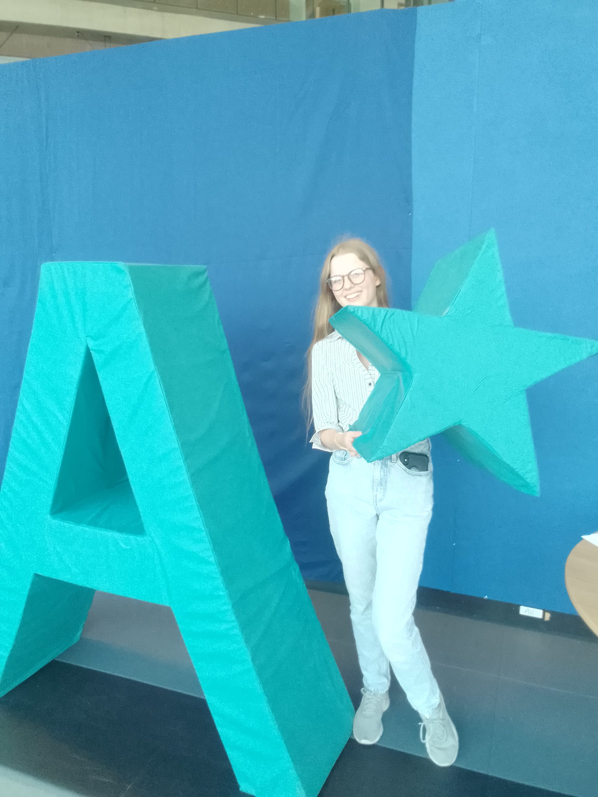 Georgina pictured on A Level results day with large blue A and star shapes