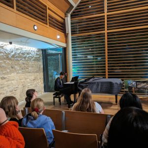 A piano recital photographed from the audience perspective in the Shulman Auditorium at Queen's