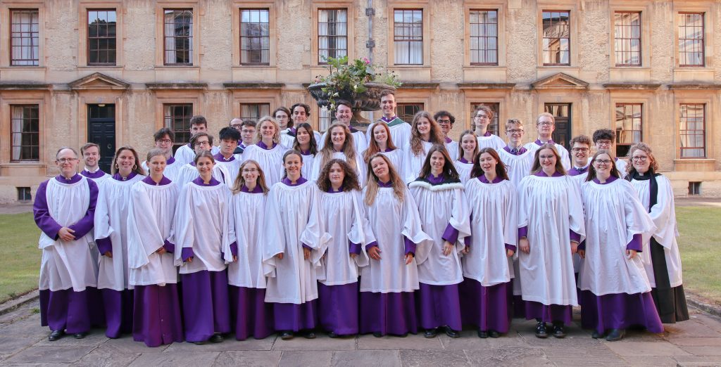Choir pictured in Back Quad dressed in purple robes with white cassocks