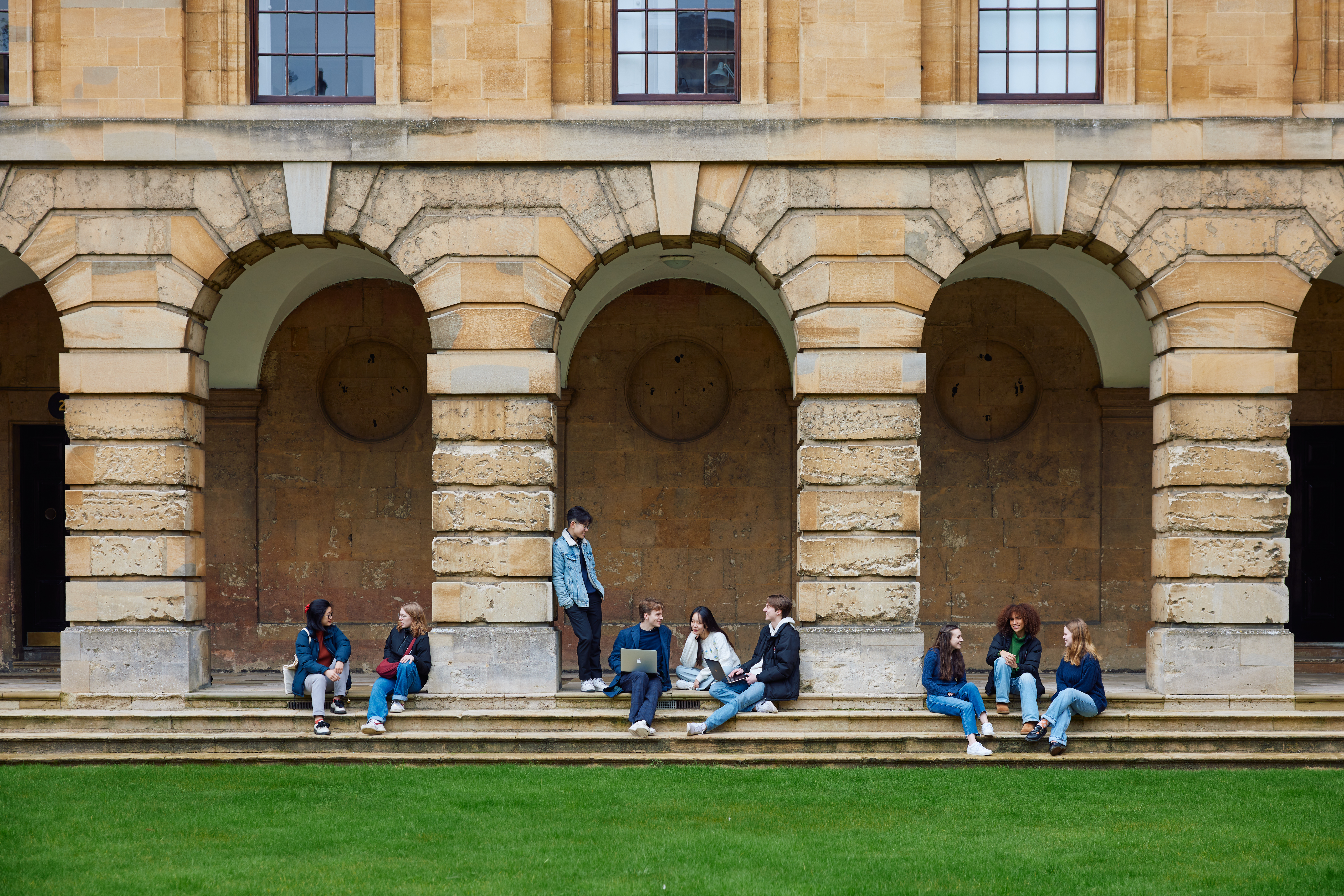 a group of students seated on the steps in the cloister