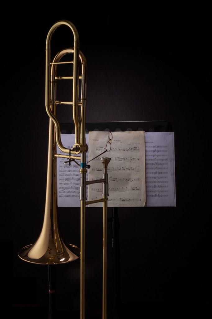 trombone in front of a music stand with a black background