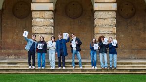 students holding up letter signs that spell 'thank you' in the Front Quad