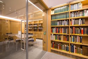 a view into the multi-purpose room through the glass door. Inside you can see a table and bookshelves in the background