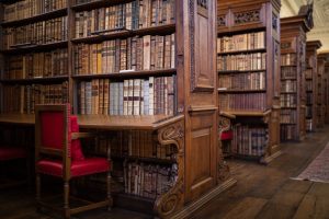old bookcases and a red leather chair in the Upper Library