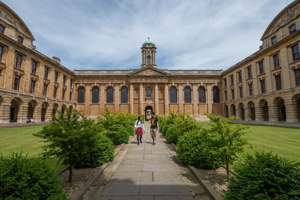 Front Quad The Front Quad of Queen's showing two students walking towards the camera down the central path chatting