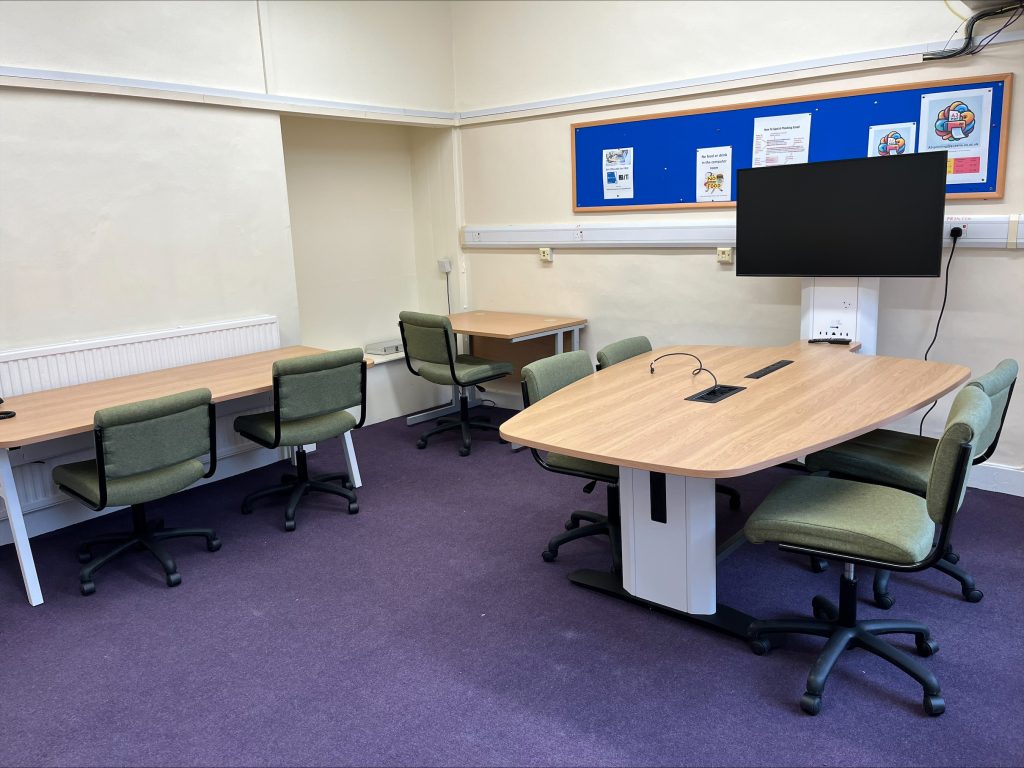 The Moffatt Computer room with desks, chairs, a pinboard and a television screen.