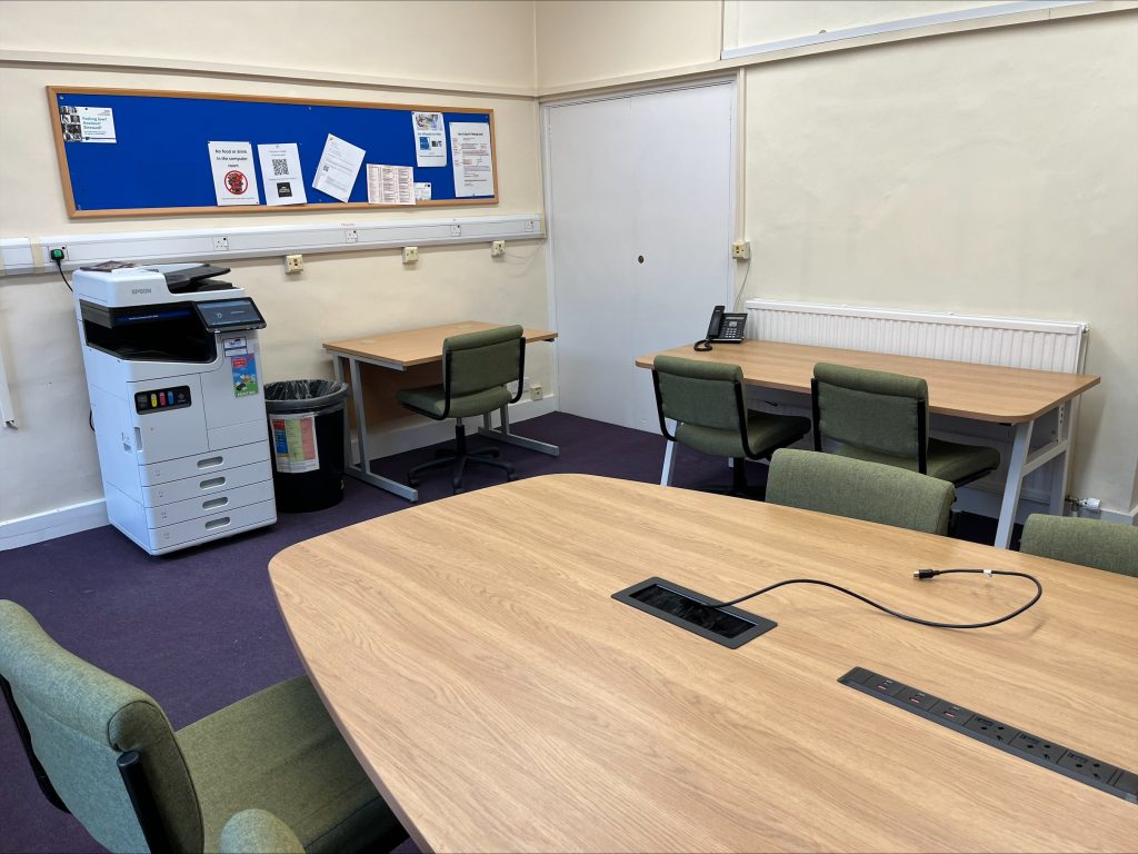 The Moffatt Computer room with desks, chairs, a pinboard and a large photocopier.