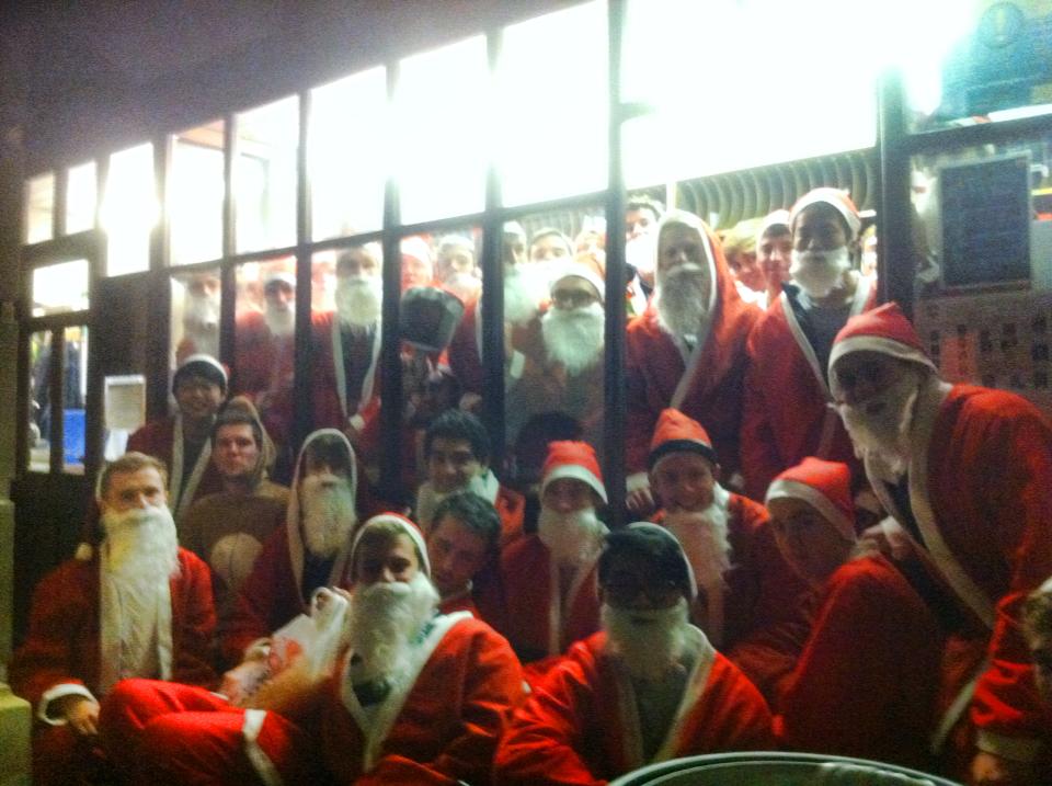 Students dressed up as Father Christmas, all huddled into the post room
