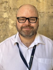 Bernard's profile photo against the College's stone walls