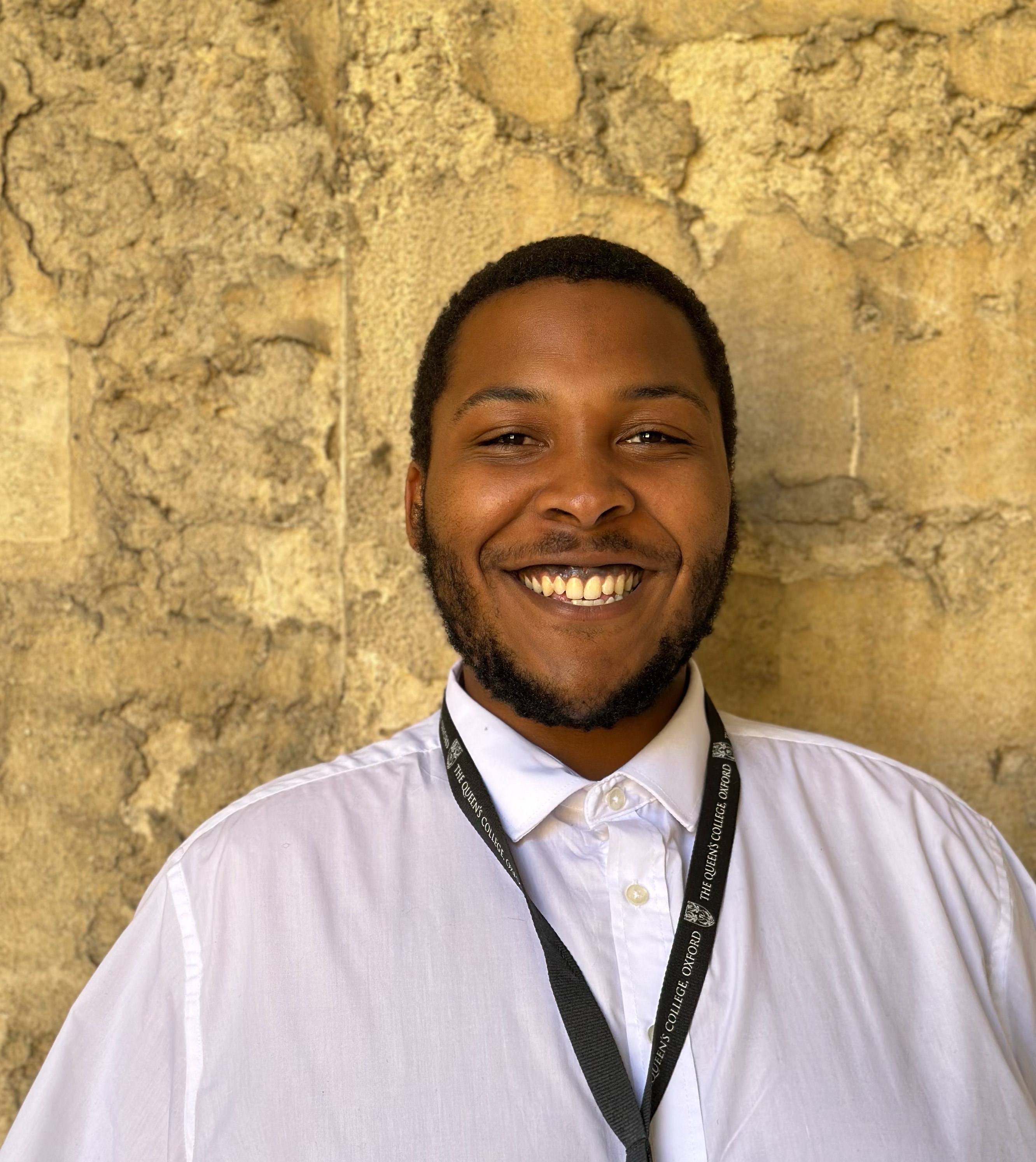 Jaydn's profile photo against the College stone walls