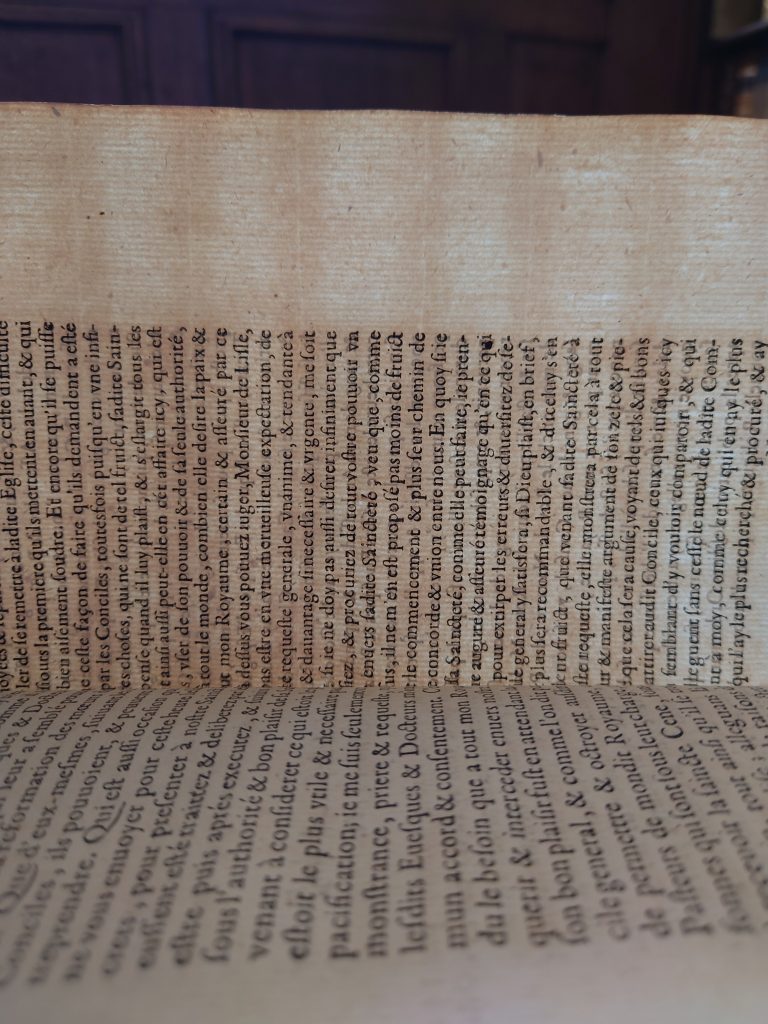 A page of antique ‘laid’ paper, when held up to light, shows a distinctive pattern thick vertical chain lines crossed by thinner horizontal lines.