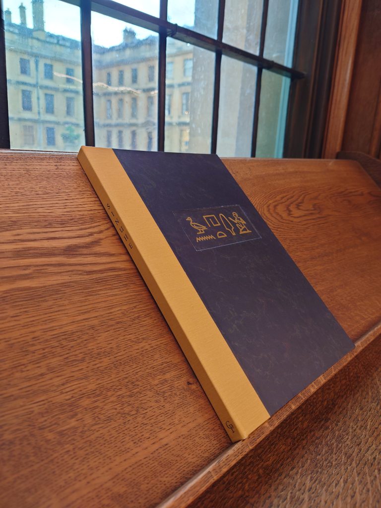 The Sinuhe book closed and sitting on a shelf by a window