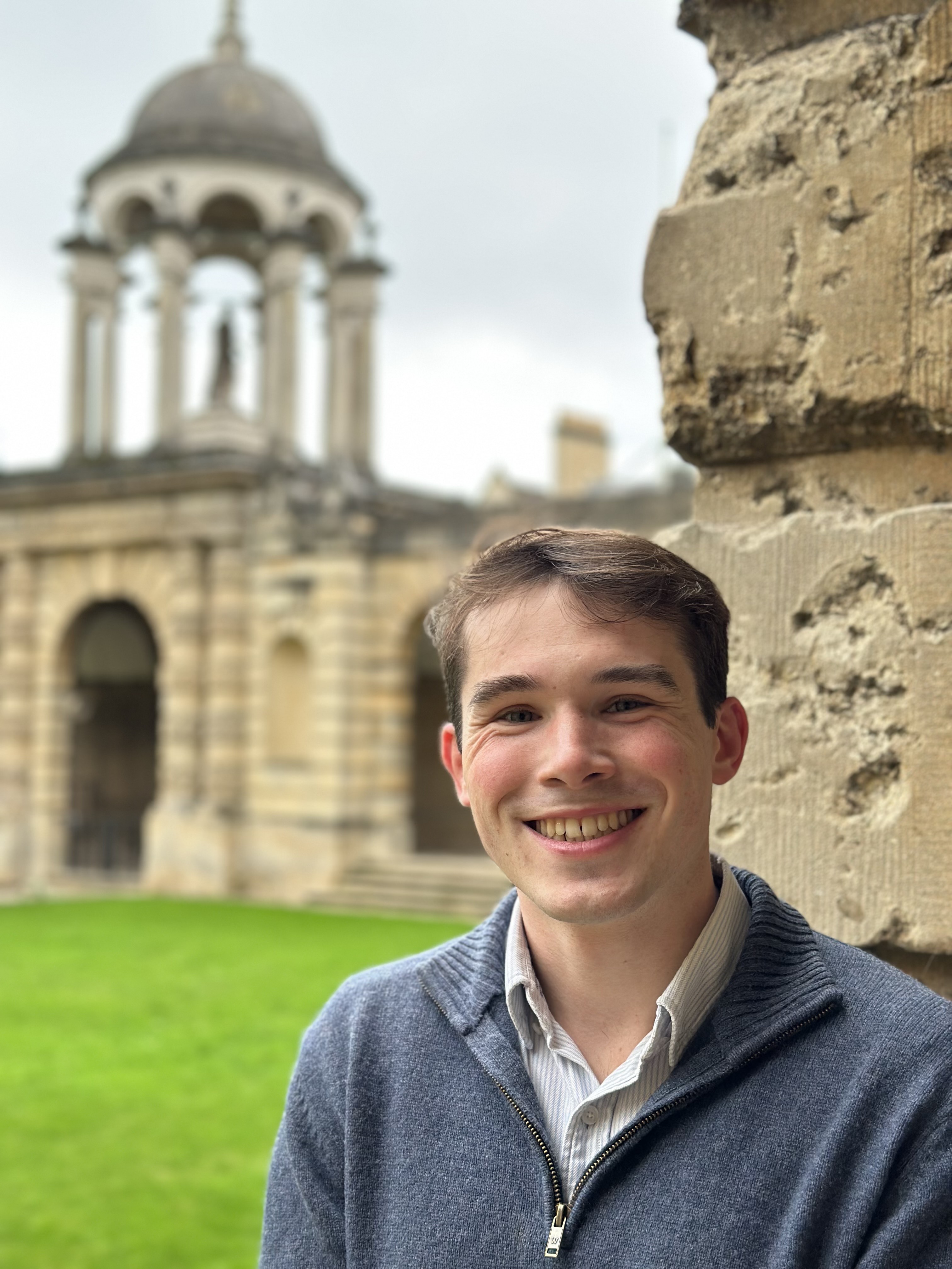 Profile photo of Dan Kelly who stands smiling in Front Quad with the cupola in the background