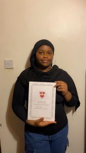 Adama holding her ABP certificate