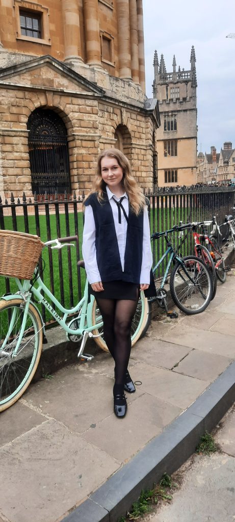 Courtney pictured in academic dress outside the Rad Cam library