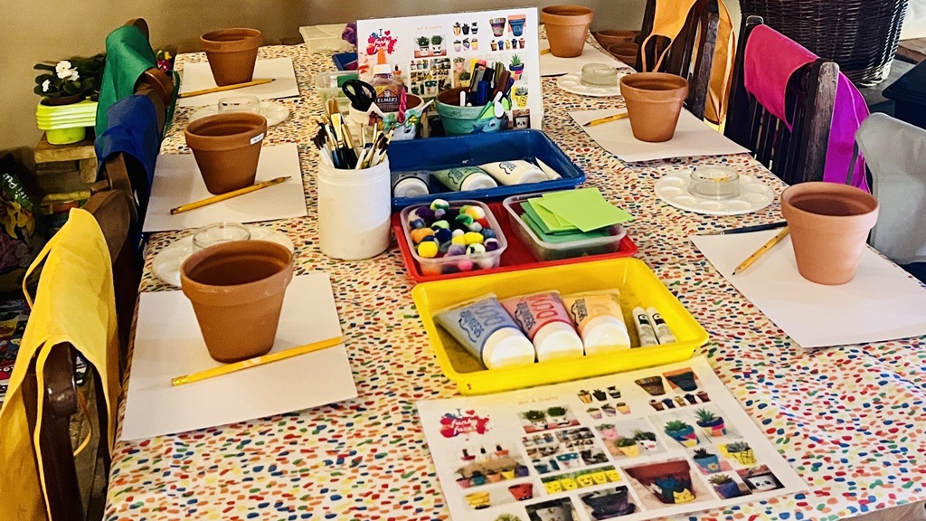 Table with set up of flowerpot painting activity