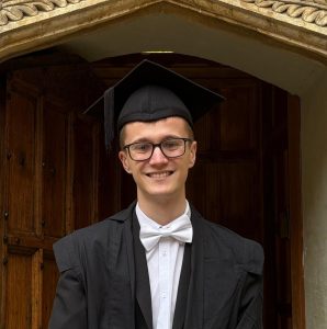 Isaac Lethbridge photographed in subfusc wearing his mortarboard