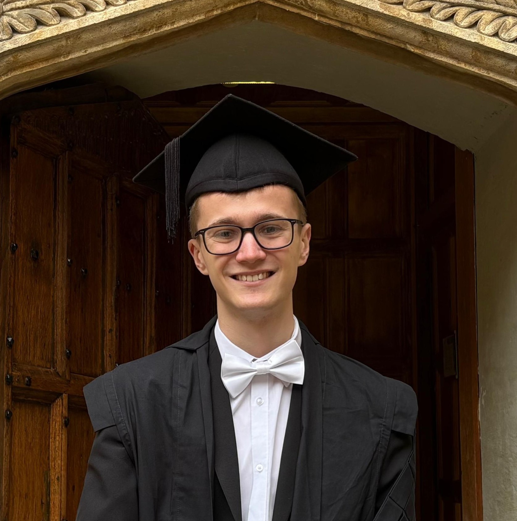 Isaac Lethbridge photographed in subfusc wearing his mortarboard
