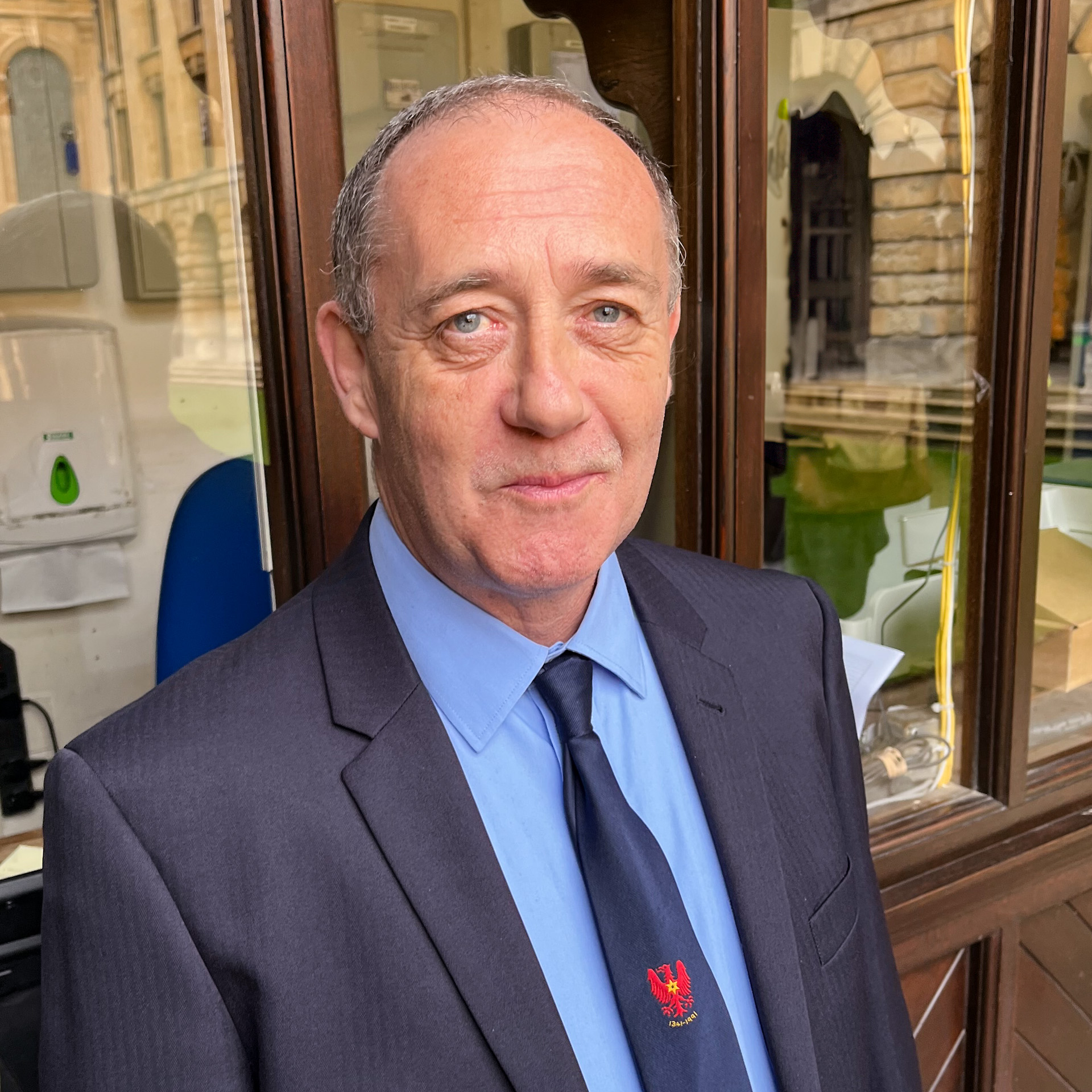 Sean Meade profile photo. Sean wears a suit and College tie