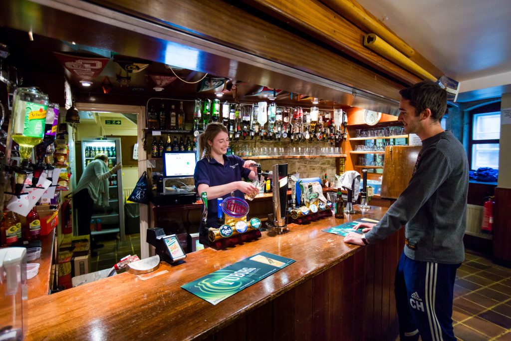 The College Bar or Beer Cellar- the image shows someone behind the bar; photo credit: Richard Wakefield