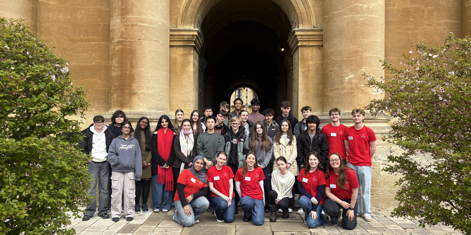 A school group pictured in Front Quad with the student ambassadors wearing red t-shirts
