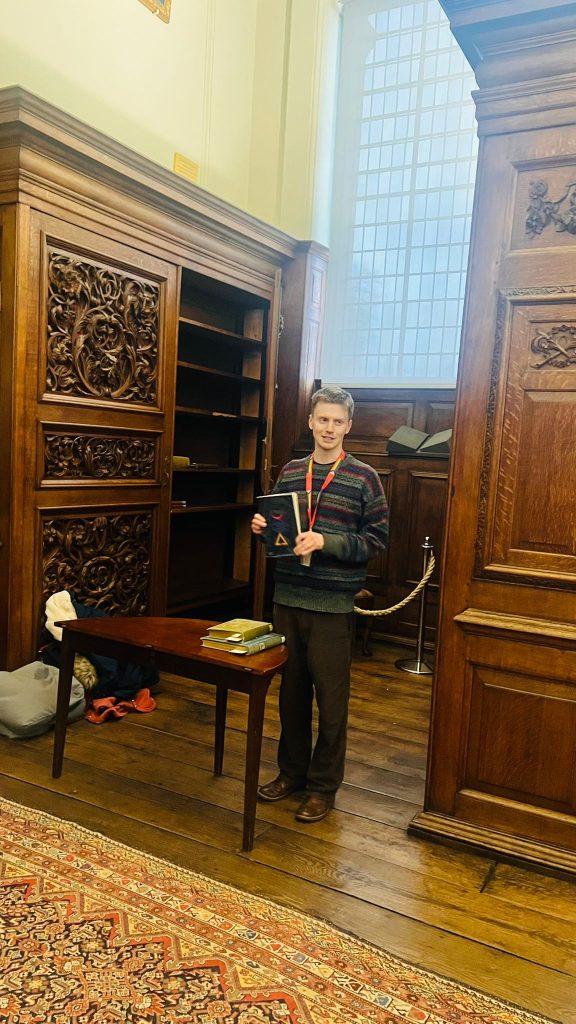 Felix pictured in the Upper Library holding his book