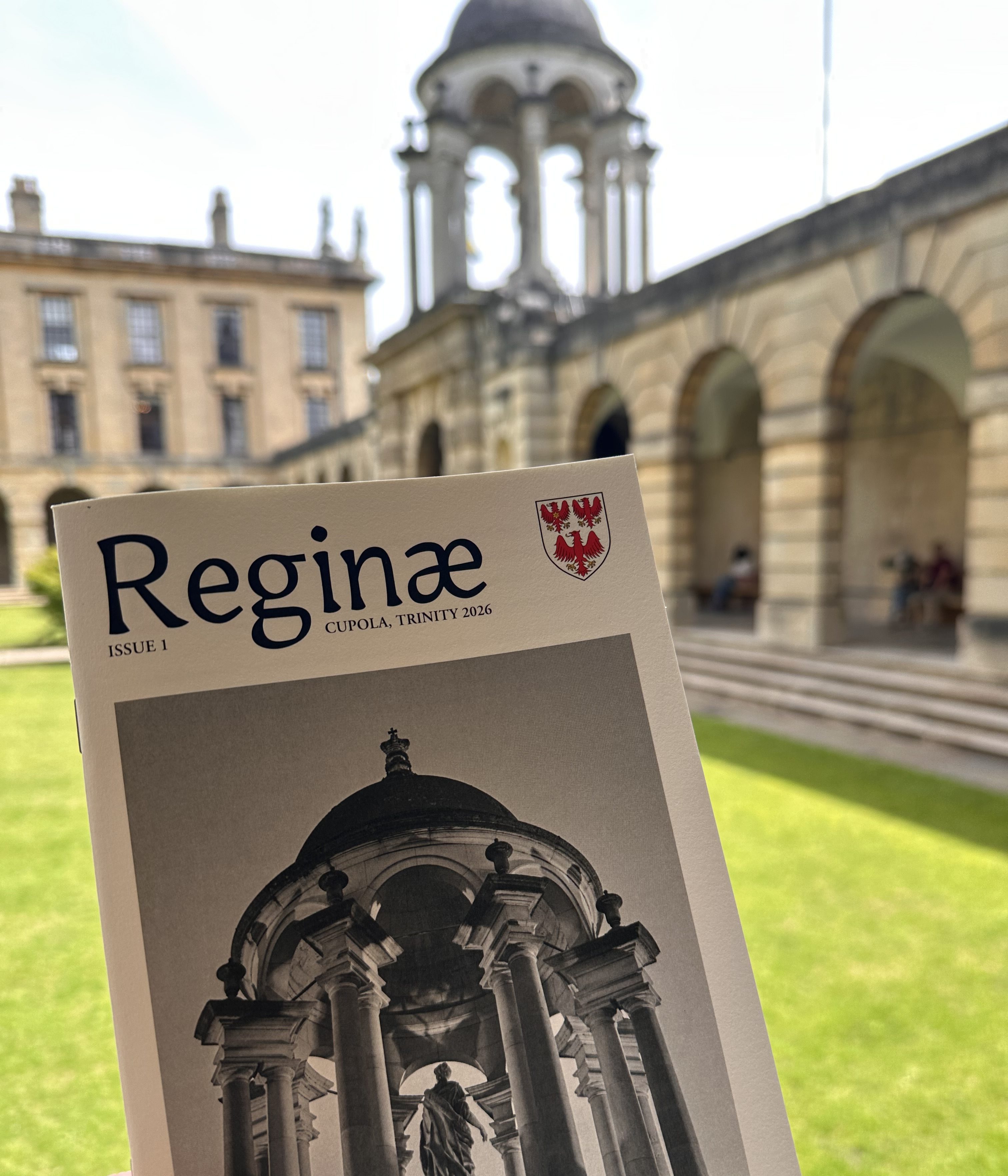 the cover of 'Reginae' showing an image of the cupola held up in front of the actual cupola in Front Quad of Queen's College