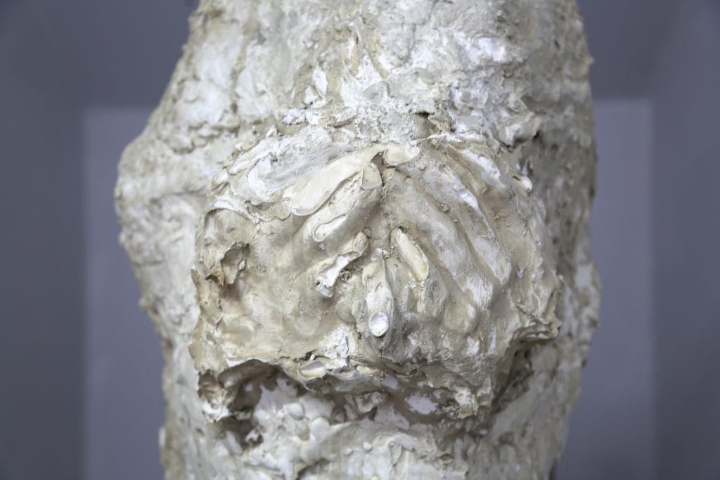 'Pillar of Sought'​ (Plaster, Clay, Chicken wire, Bandages, Scrim​) by Maia Szulta; image depicts plasterwork sculpture showing clear hand/finger print marks