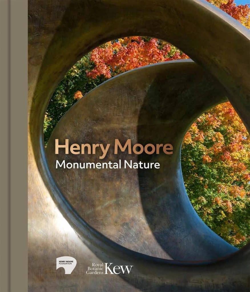 Close-up of Henry Moore's abstract sculpture with autumn trees in background.